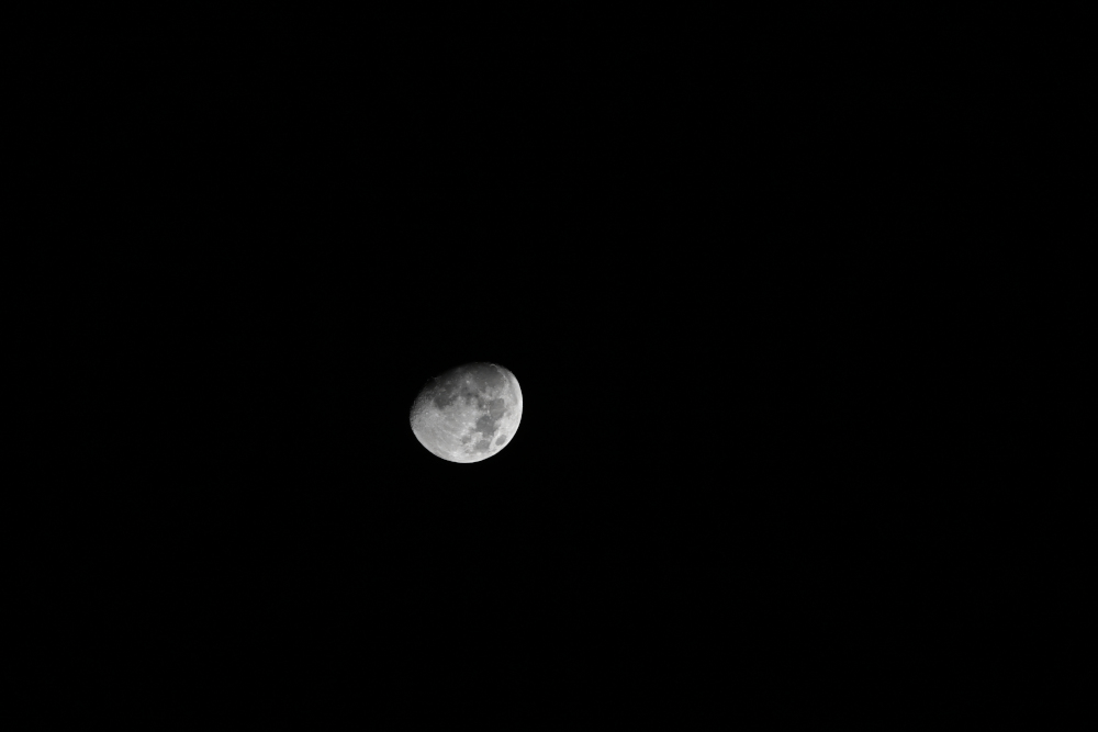 Three quarter of moon at night in Karlovy Vary.